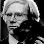 Fotoporträt von Andy Warhol mit Dachshund Archie (1973)