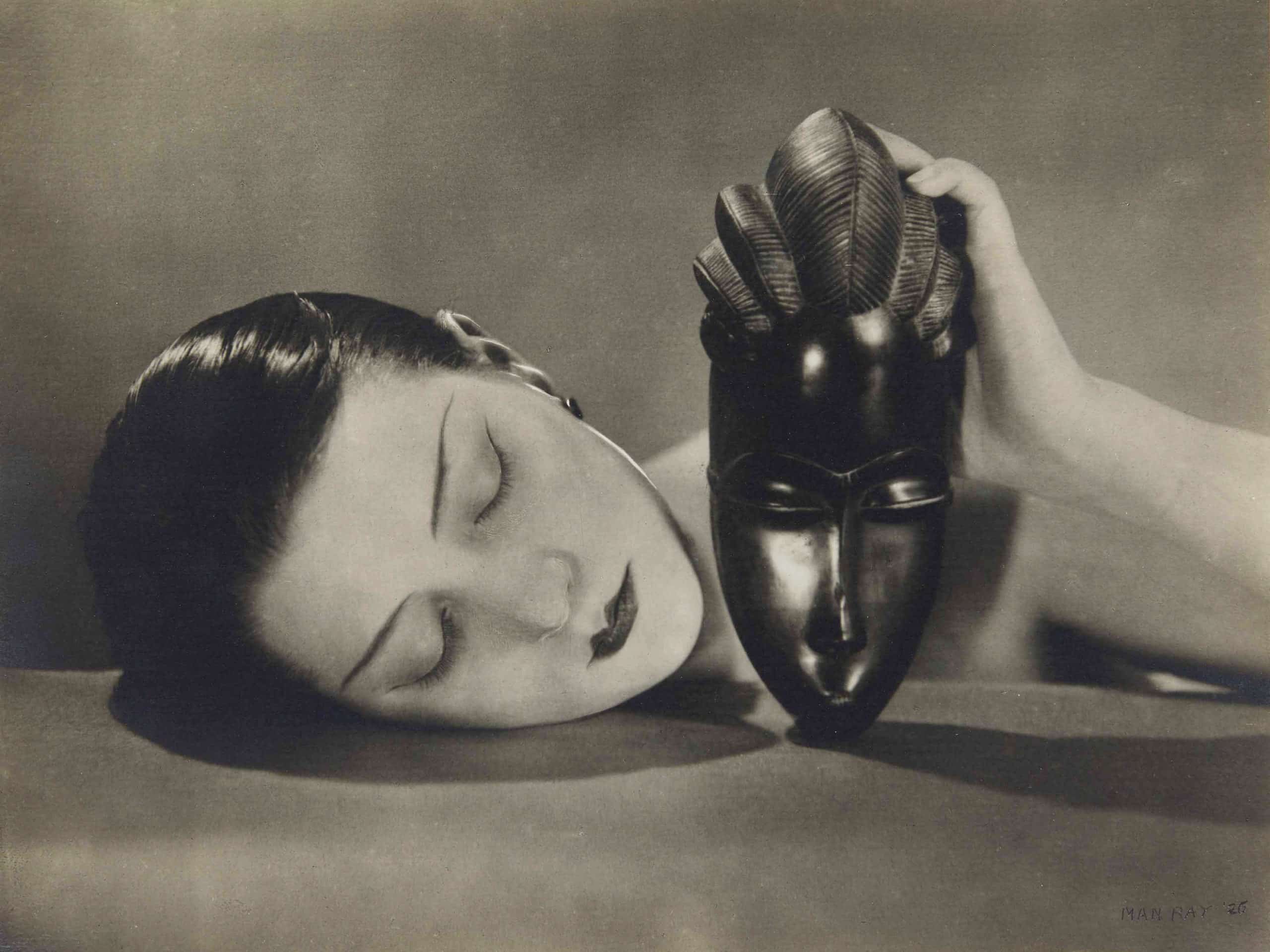 Noire et Blanche von Man Ray, 1926, Silbergelatineabzug, 6 7/8 x 8¼ Zoll (17,5 x 21 cm). Dieses Foto wurde in der Maiausgabe 1926 der französischen Vogue veröffentlicht, begleitet von der eleganten Beschreibung „Perlmuttgesicht und Ebenholzmaske“.