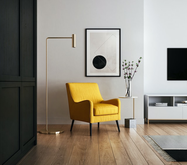 Wunderbares Beispiel einer minimalistischen Inneneinrichtung in schwarz-weiß mit natürlichem Holzboden und einem Farbtupfer durch den gelben Sessel, ergänzt durch subtile und zurückhaltende Präsentation eines abstrakten Kunstwerks