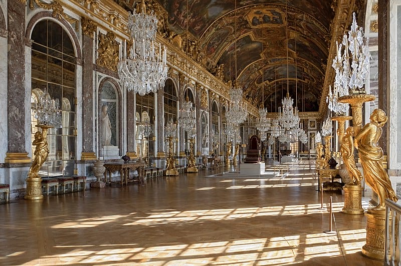 Sämtliche Kunstgegenstände des Raumes ergeben im Zusammenspiel mit den gemalten Deckengemälden eine prächtige Ausstattung für den Spiegelsaal von Ludwig XIV. auf Schloss Versailles.