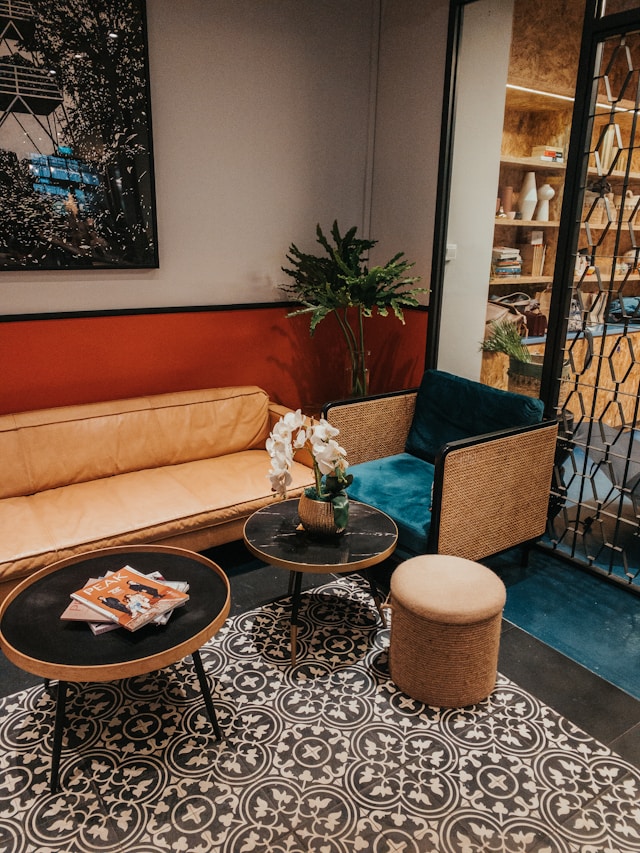 Es muss nicht immer monumental dimensioniert sein. Auch kleinen Ecken in einer Lounge kann mit einer stilvollen Möbelauswahl Charakter und Charme eingehaucht werden. Hier mit runden Couchtischen und Sitzmöbeln, welche das Muster- und Farbspektrum des Innenraums perfekt ergänzen.