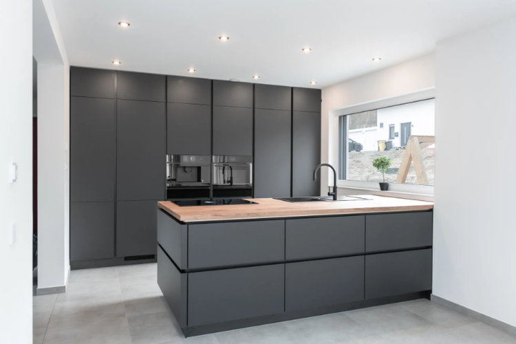 Moderne Designküche in elegantem Schwarz mit Holzakzenten, geplant und eingebaut von Adam Küchenstudio.