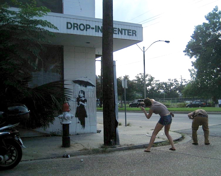 Schaulustige fotografieren ein Banksy-Werk am Drop-in Center in New Orleans