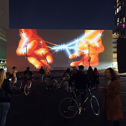 A mural is admired by nighttime passers-by - the motif could be symbolic of our topic.