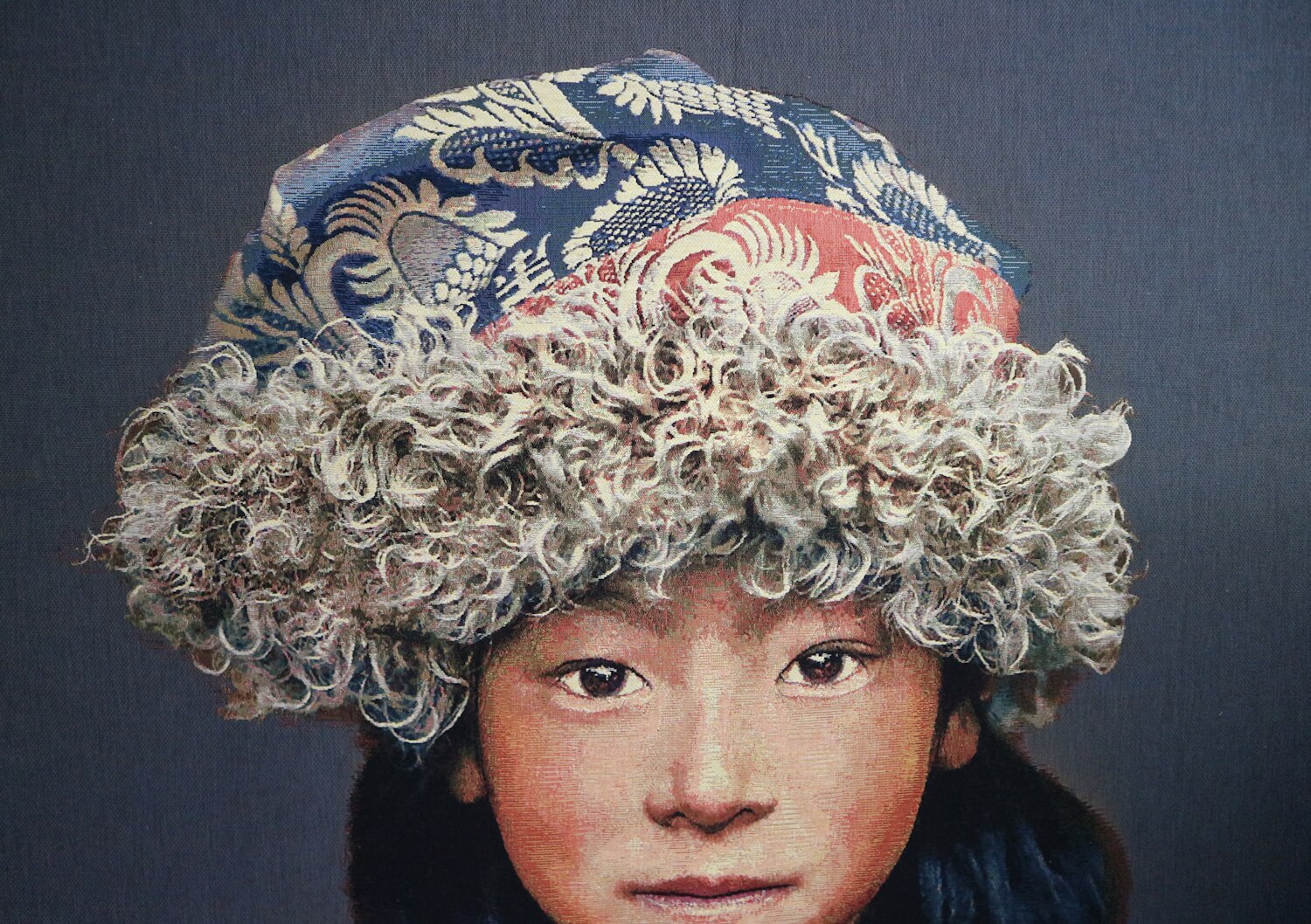 Tapiz de pared tejido a mano "Niño tibetano 2" de Alison Wright, fonoabsorbente (sobre bastidor, fondo gris) Tapiz de pared tejido a mano “Niño tibetano 2” de Alison Wright, tensado sobre un bastidor y con material fonoabsorbente (fondo gris)