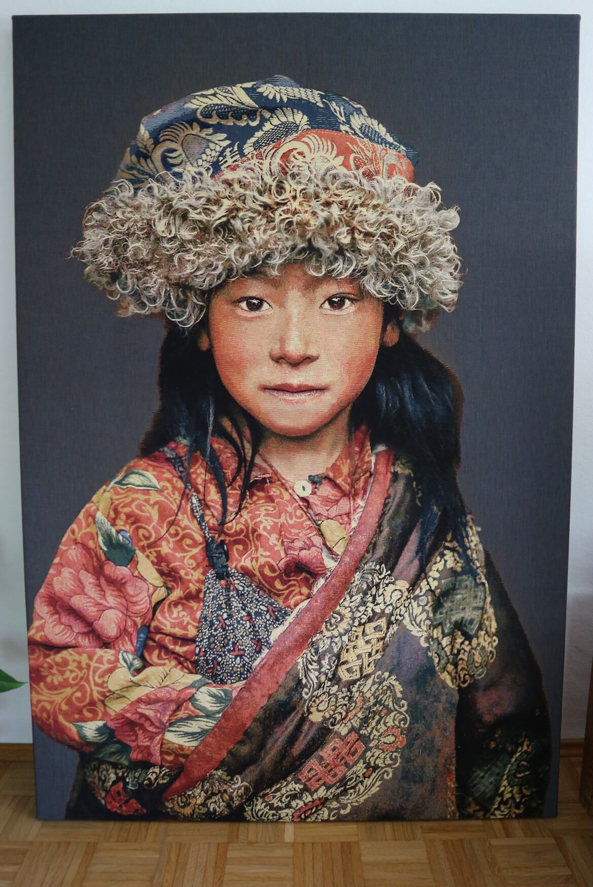 Tapiz de pared tejido a mano "Niño tibetano 2" de Alison Wright, fonoabsorbente (sobre bastidor, fondo gris) Tapiz de pared tejido a mano “Niño tibetano 2” de Alison Wright, tensado sobre un bastidor y con material fonoabsorbente (fondo gris)