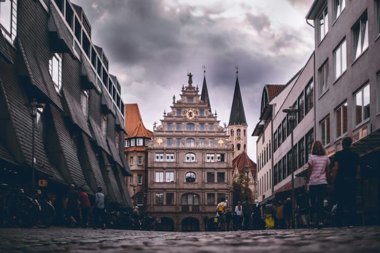 Geschichten von versteckten Bau-Schätzen in Braunschweig Wanddeko biedermeier Historisches Braunschweig: Das markante Gebäude in der Bildmitte mit dem prächtigen Renaissance-Treppengiebel ist das historische Gewandhaus, das sich am Altstadtmarkt befindet. Direkt dahinter ragen die beiden charakteristischen, spitzen Türme der Martinikirche (St. Martini) in den Himmel.