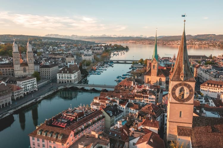 Raum und Resonanz: Zürichs architektonische Vielfalt als Kulisse für moderne Feierlichkeiten Tipps für Künstler altstadt Blick auf die Altstadt von Zürich. Perspektive über den Fluss Limmat in Richtung Süden zum Zürichsee, der im Hintergrund liegt.